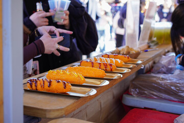Delicious Korean style hot dogs (Hatdog) with mustard and ketchup on wooden counter