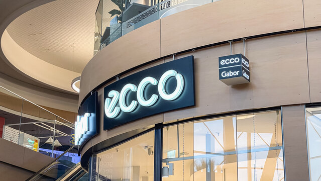 February 15, 2026, Lubeck, Germany: Ecco store illuminated sign on curved mall facade near escalator