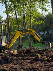Mini excavator working at small construction site © Tatiana