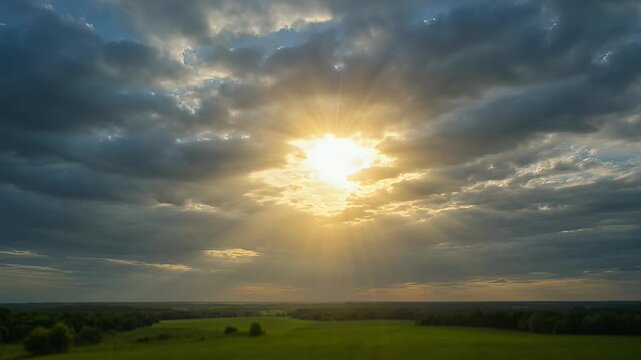 Dramatic Sky Over Green Fields as Sunlight Breaks Through Stormy Clouds