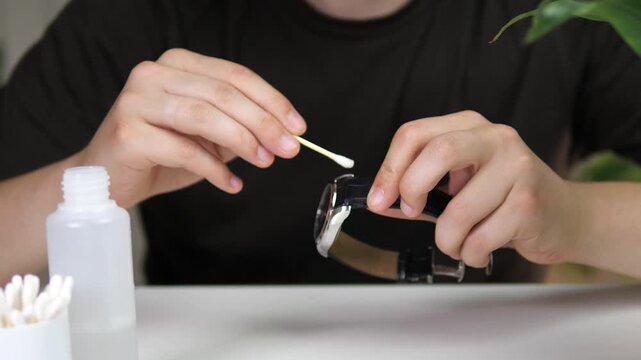 Macro shot of cleaning a wristwatch using a cotton swab and sanitizer. DIY tech maintenance and hygiene routine. High-quality footage for product care guides, gadget reviews, and daily cleaning