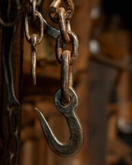 Close-up of metal hook and chain in warm workshop light