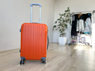 Orange suitcase standing on floor ready for trip