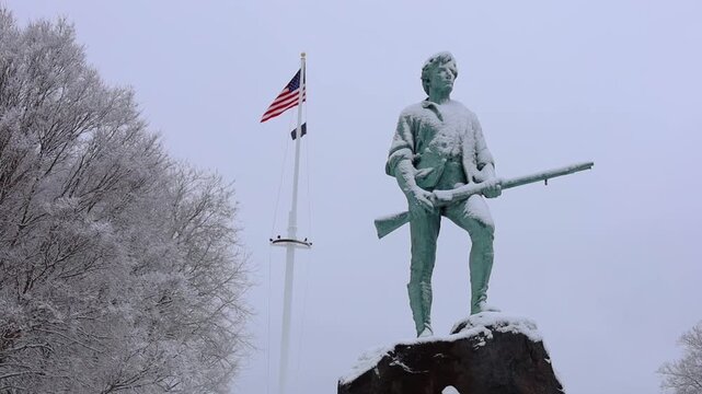 Minuteman Statute with waving American background at Lexington &ndash; Massachusetts. 250th Anniversary on Feb. 21, 2026.
