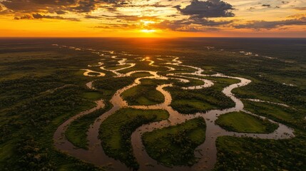 Golden Hour Sunset Illuminates a Meandering River Through a Lush Tropical Landscape, Aerial View