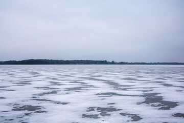 Frozen lake ice and snow covering winter landscape