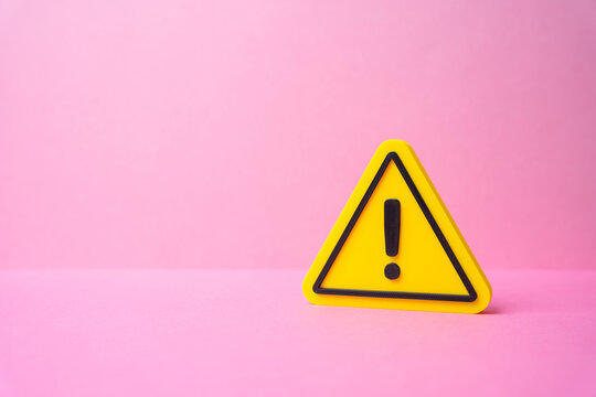 Yellow attention sign on pink background. Important message and information. Minimal warning symbol design for announcements marketing alerts and communication concept.