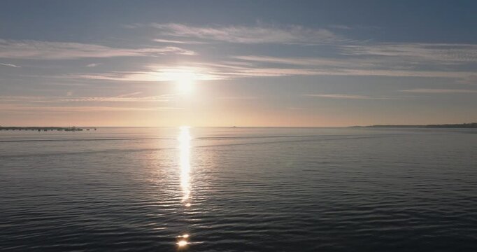 Aerial drone shot golden hour towards Atlantic Ocean horizon and Bugio lighthouse, Estoril and Cascais