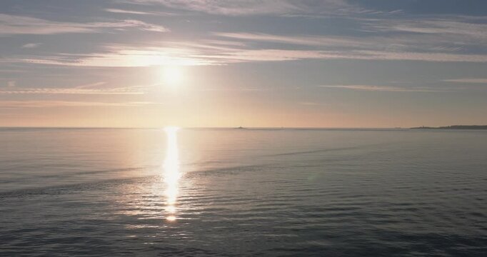 Aerial drone shot golden hour towards Atlantic Ocean horizon and Bugio lighthouse, Estoril and Cascais