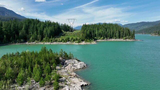 Aerial Over Turquoise Green Lake with Power Lines and Forested Island, Whistler BC