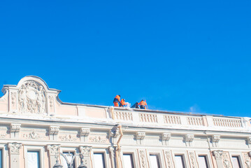 Workers cleaning snow from roof of beautiful historic building © Ruslan Russland