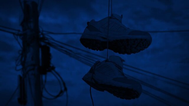 Shoes Hang From Telephone Line At Night