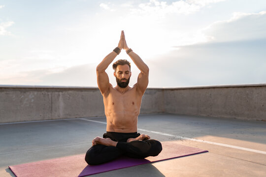attractive hansome man with athletic strong body doing morning yoga dzen meditation
