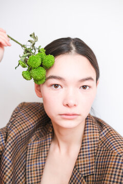 Unique portrait of a model with green floral accents