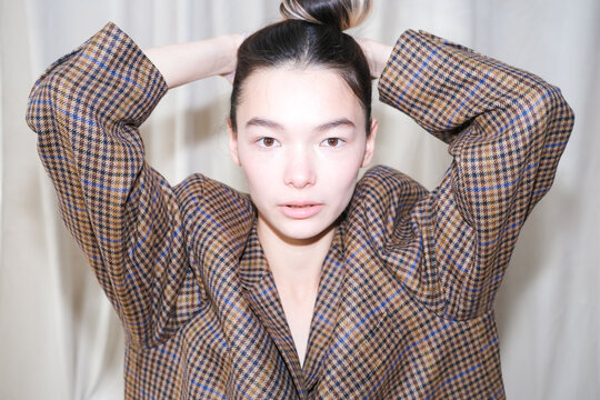 Model showcases elegant style with hairstyle and checkered blazer