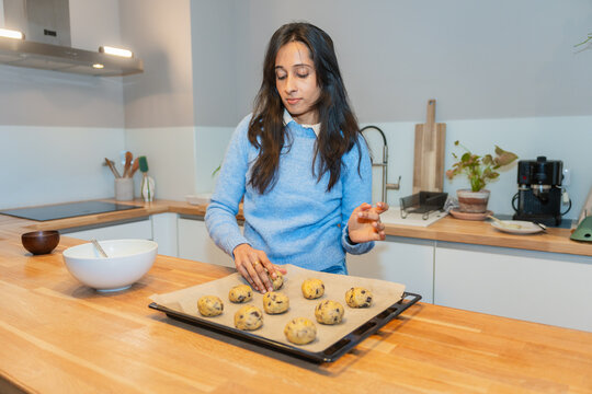 Woman Arranging Cookie Dough On Tray