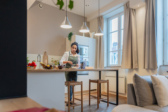 Woman Mixing Ingredients In Modern Kitchen