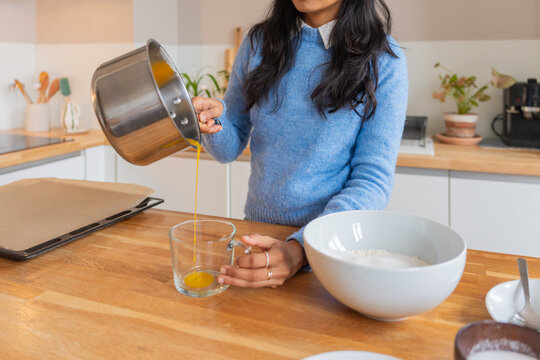 Woman Pouring Melted Butter Into Glass Cup