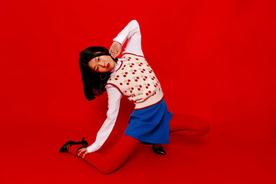Confident female dancing in red studio