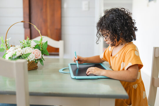 Girl drawing on toy blackboard