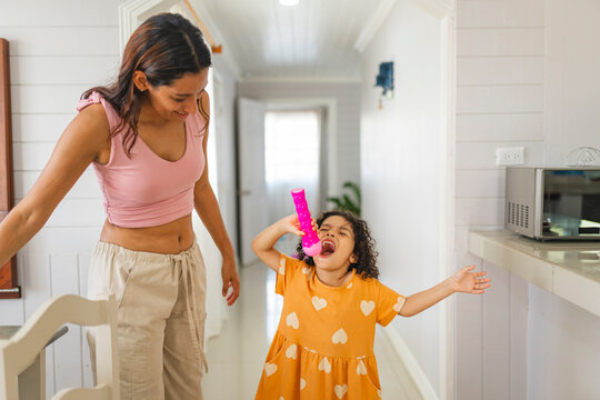 Little girl pretending to sing with toy microphone