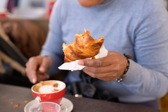 Female hand holding a bitten croissant