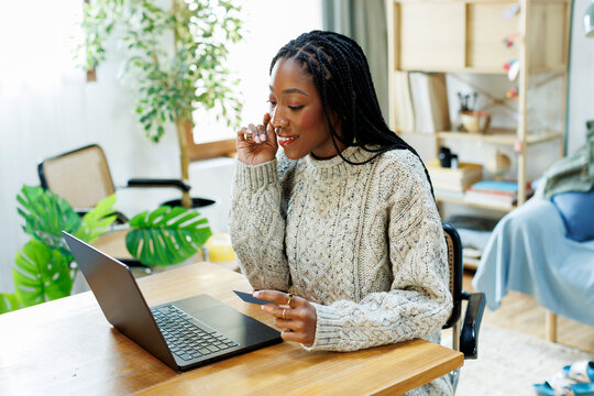 Smiling Woman shopping online using credit card