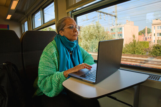 Woman Working on Laptop in Train