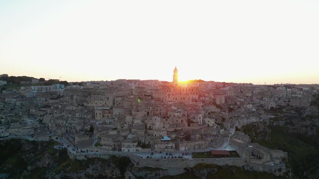View approaching Matera, with its church hiding the sunset, in Italy