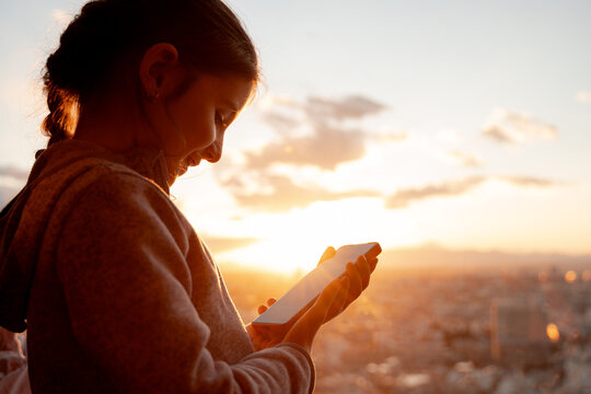 Happy Girl Using mobile at Sunset 