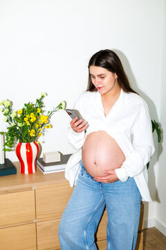 Pregnant Woman Checking Phone at Home with flash light