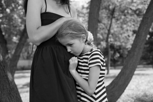 mother and daughter are standing in the park