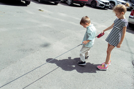 little boy and girl are standing on the road