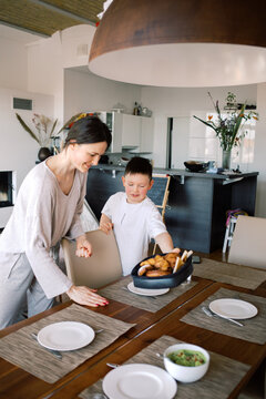 Mother and son setting the dining table