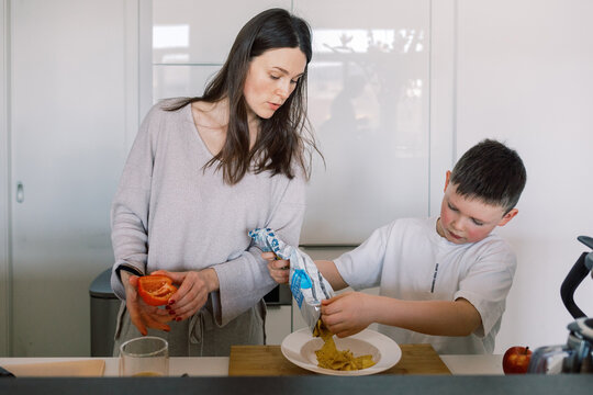 Mother and son preparing food together in the kitchen