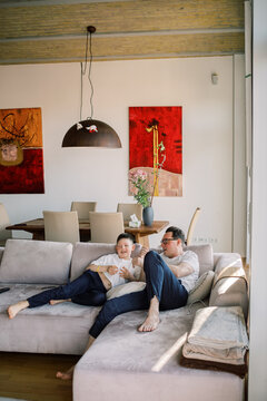 Father and Son Playfully Relaxing on Couch