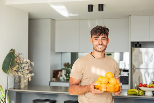 Man showcasing vibrant oranges in a modern setting in Australia