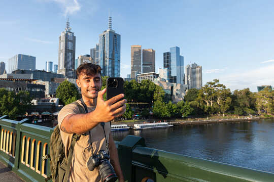 Smiling man takes a selfie in front of Melbourne Australia city