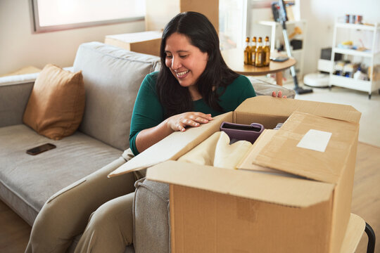Smiling woman unpacking items from a box