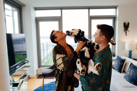 Gay Couple Playing with Dalmatian in Modern Apartment