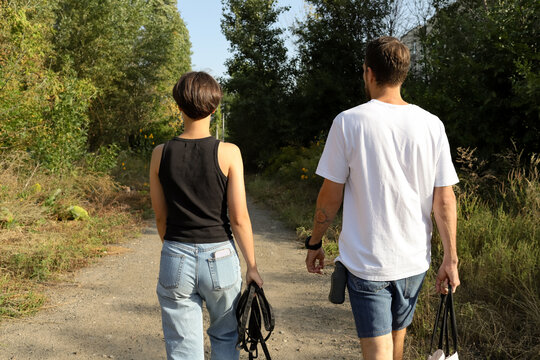 a man and a woman walk with a dog on the street