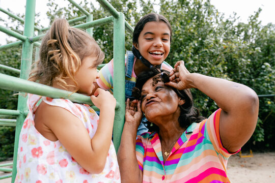 Grandmother plays with granddaughter's hair.