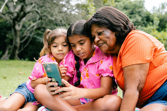 Grandmother and Granddaughters Enjoying Content on a cellphone