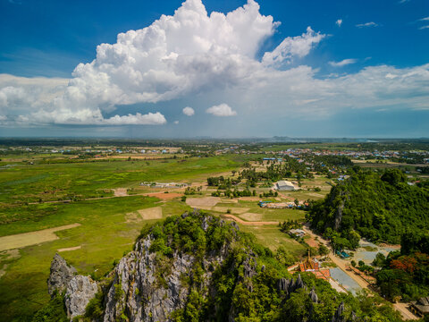 Limestone hills and rural farmland under dramatic clouds in Kampot Province