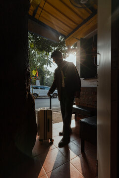 Man with Suitcase in Doorway at Dawn
