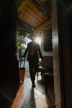 Man Enters with Suitcase at Sunrise