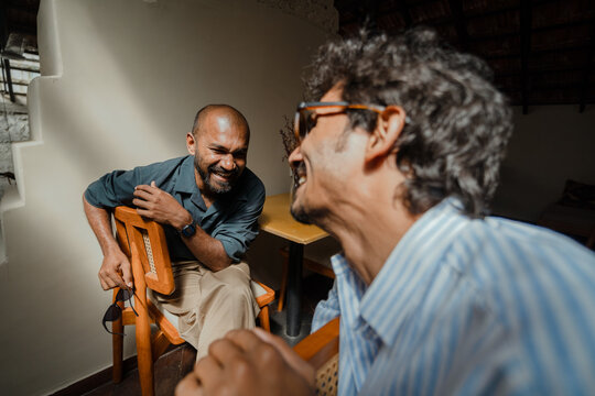 Candid moments of two friends laughting Indoors