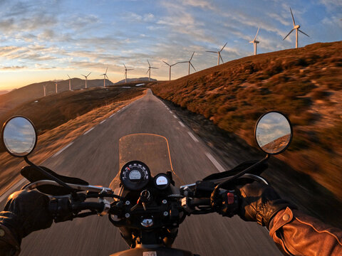 POV ride on mountain road. Sunset light and wind generators 