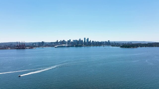 Rising Aerial Reveal of Downtown Vancouver Skyline with Boats Crossing the Harbor