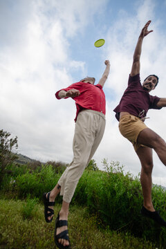Two men trying to catch a frisbee